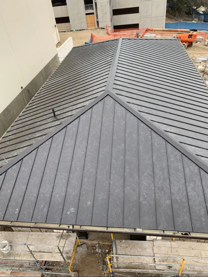 Commercial metal roof construction with crane equipment in Glasgow